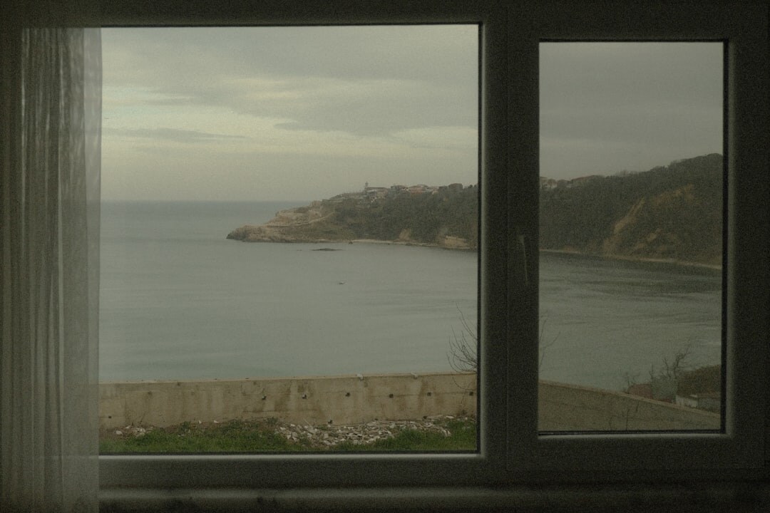 Modern hotel room with sea view through open curtains