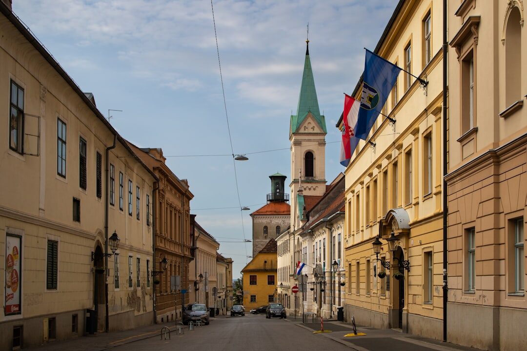 Blue tram passing through a historic Zagreb street