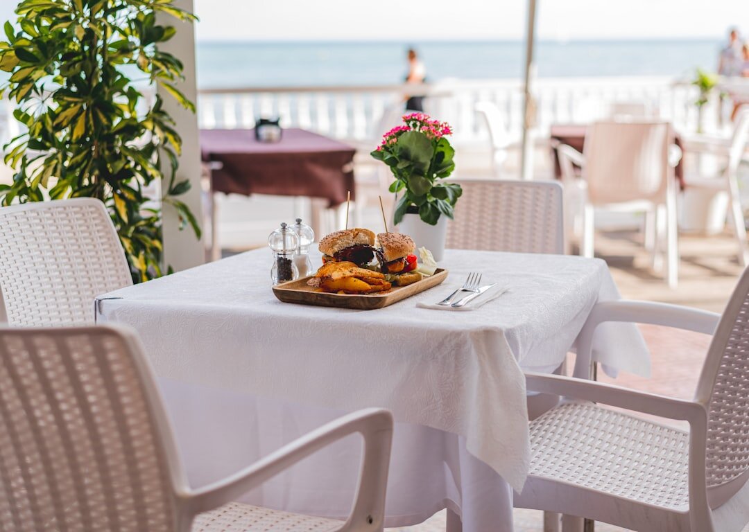Outdoor restaurant terrace set for dinner near the sea