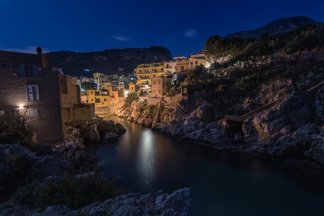 Night view of a lit coastal town from the water